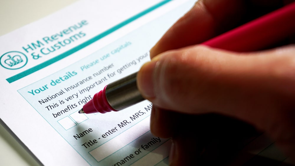 Hand filling out HMRC form